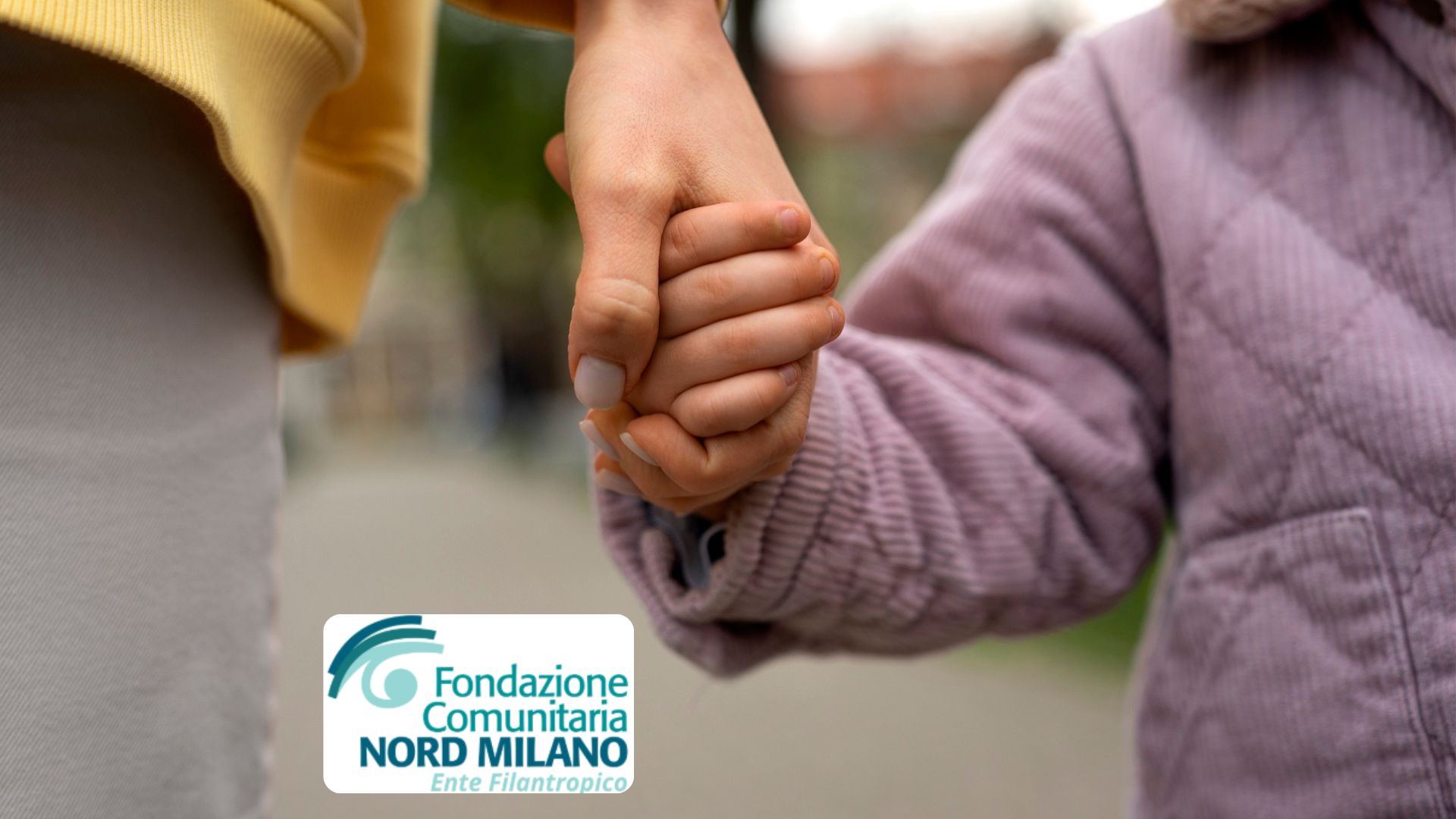 Mamma che stringe la mano alla figlia.